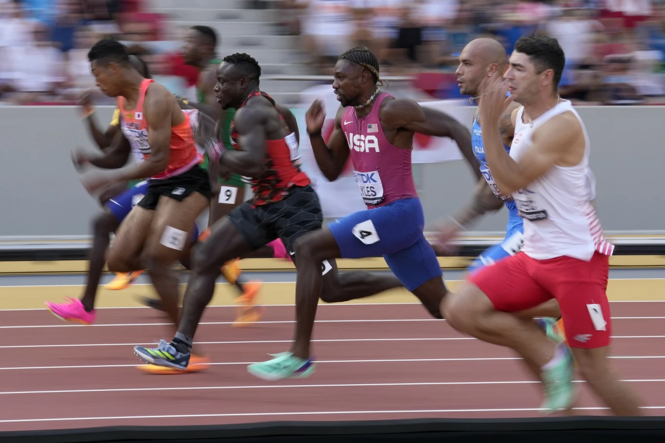 Dominik Kopeć obok gwiazd. Na zdjęciu m.in. Noah Lyles czy Ferdinand Omanyala Zawodnicy w trakcie biegu sprinterskiego na stadionie lekkoatletycznym, dynamiczny moment wyścigu, wszyscy sportowcy w mocno pochylonej pozycji, skupienie widoczne na twarzach, tłum widzów w tle