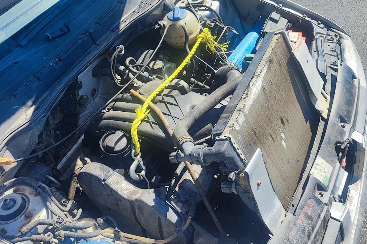 Chłodnicę przeniesiono wyżej, przez co nie był narażona na uszkodzenia podczas jazdy w terenie Silnik samochodu z prowizorycznymi naprawami, widoczny żółty sznurek utrzymujący elementy pod maską oraz nieoryginalnie zamocowana chłodnica.