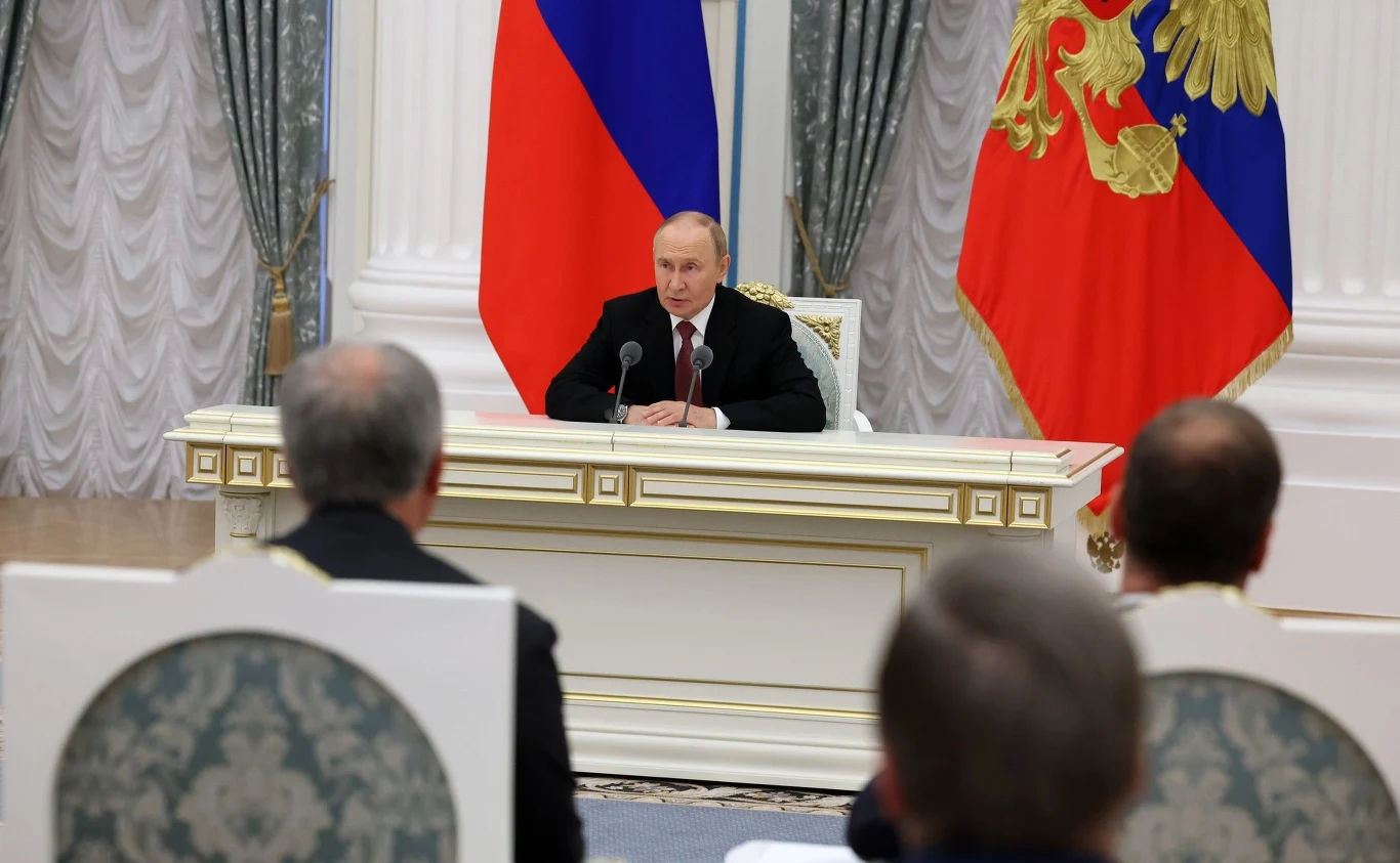 Władimir Putin przedstawił rosyjskiemu rządowi efekty rozmów z Donaldem Trumpem Mężczyzna siedzący przy dużym, ozdobnym stole, za nim znajdują się dwie rosyjskie flagi, przed nim siedzi kilku mężczyzn widocznych od tyłu, wnętrze jest bogato zdobione i reprezentuje styl oficjalny.