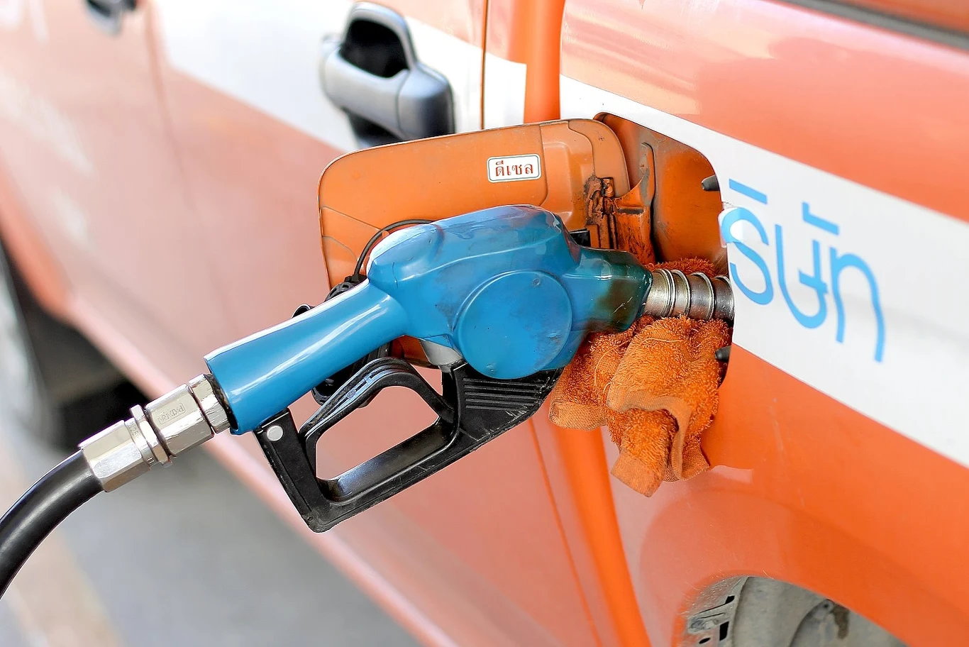 Na Krymie i w Kraju Zabajkalskim paliwo tylko na kartki. Kierowcy tankują za łapówki Pomarańczowy samochód jest tankowany przy użyciu niebieskiego pistoletu dystrybutora paliwa, uchwyt pompy zabezpieczony jest pomarańczową szmatką umieszczoną wokół wlewu paliwa.