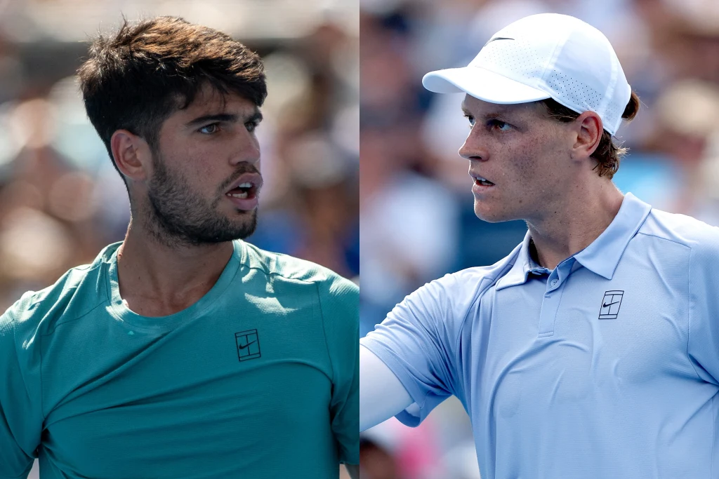 Dwóch młodych, skoncentrowanych tenisistów ubranych w sportowe koszulki, jeden w turkusowej, drugi w jasnoniebieskiej, z wyrazami skupienia i determinacji na twarzy na tle rozmytego tłumu kibiców.