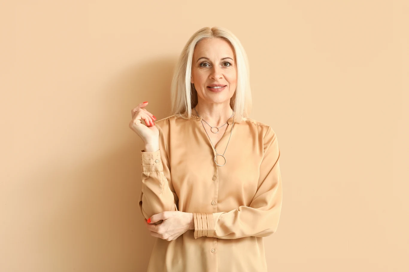 Wróżka Diana ułożyła tarota dla wszystkich znaków. Sprawdź, co się wydarzy w czwartek Kobieta w średnim wieku o jasnych, długich włosach uśmiecha się, stojąc na tle jasnobeżowej ściany, ubrana w beżową bluzkę, z delikatnym makijażem i dłońmi delikatnie uniesionymi.