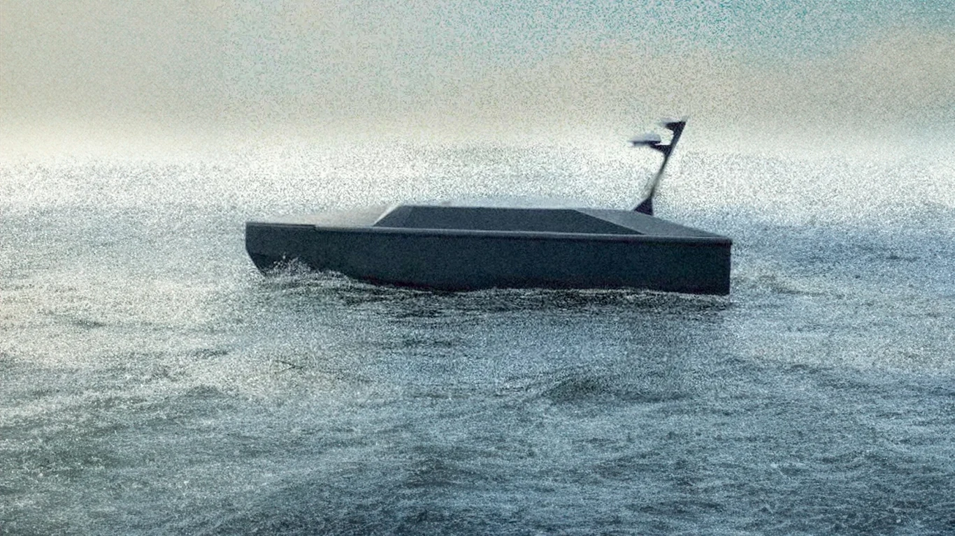W Zatoce Gdańskiej pojawił się tajemnicy dron. To Stormrider Bezzałogowa łódź o kanciastych kształtach płynie po wzburzonych wodach, w tle mglista atmosfera ograniczająca widoczność, na dziobie umocowana niewyraźna flaga.