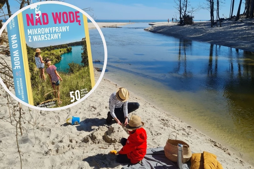 "Nad Wodę" to propozycja nie tylko na lato Dwoje dzieci bawi się na piaszczystej plaży przy spokojnej rzece, obok leży wiklinowy kosz i koc piknikowy, w tle widoczne szerokie ujście rzeki do morza; w lewym górnym rogu widoczna okładka przewodnika turystycznego o mikrowyprawach z Warszawy.