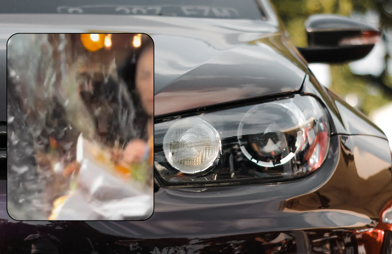 Influencerzy mieli dużo szczęścia. Skończyło się na kilku szwach. Inne podobne przypadki często niosły za sobą ofiary śmiertelne. Zbliżenie na reflektor nowoczesnego, czarnego samochodu z lusterkiem odbijającym rozmyty obraz osoby oraz światła.