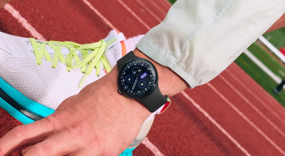 Google Pixel Watch 4 oferuje spersonalizowanego asystenta zdrowia opartego na Gemini. Ręka sportowca z założonym smartwatchem, sportowy but z jasnożółtymi sznurówkami na bieżni lekkoatletycznej, gotowość do startu