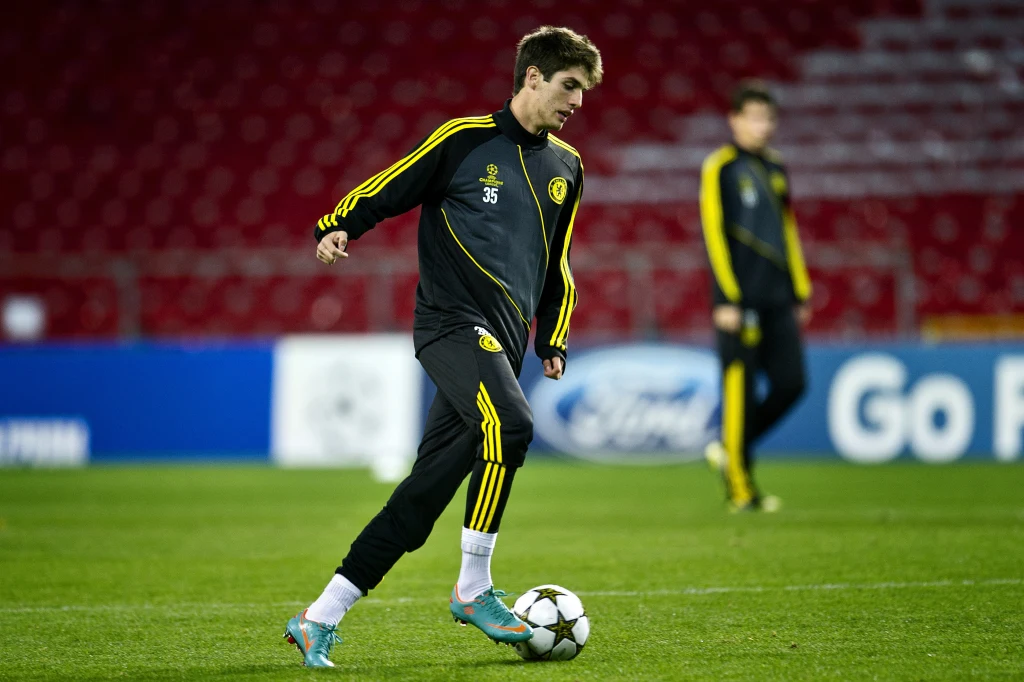 Nowy zawodnik Wieczystej ma za sobą występy m.in. w barwach Chelsea Młody piłkarz w dresie treningowym Chelsea trenuje z piłką na zielonej murawie stadionu, w tle drugi zawodnik oraz czerwone trybuny.