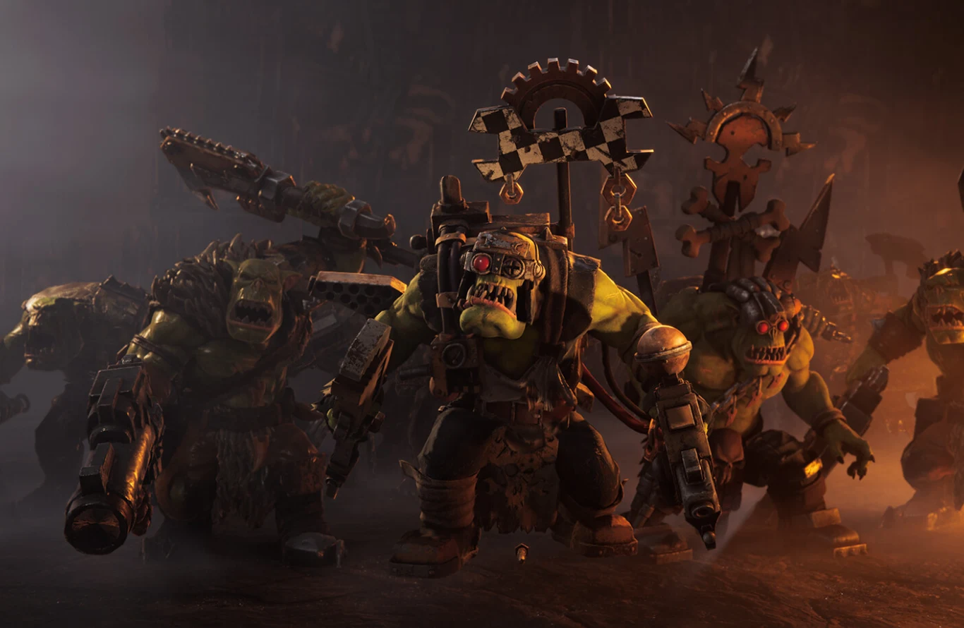 Warhammer 40,000: Dawn of War IV Grupa fantastycznych orków uzbrojonych w różnorodną broń i pancerze, prowadząca marsz w stronę obserwatora, w tle widoczne są steampunkowe elementy i atmosfera bitewnego chaosu.