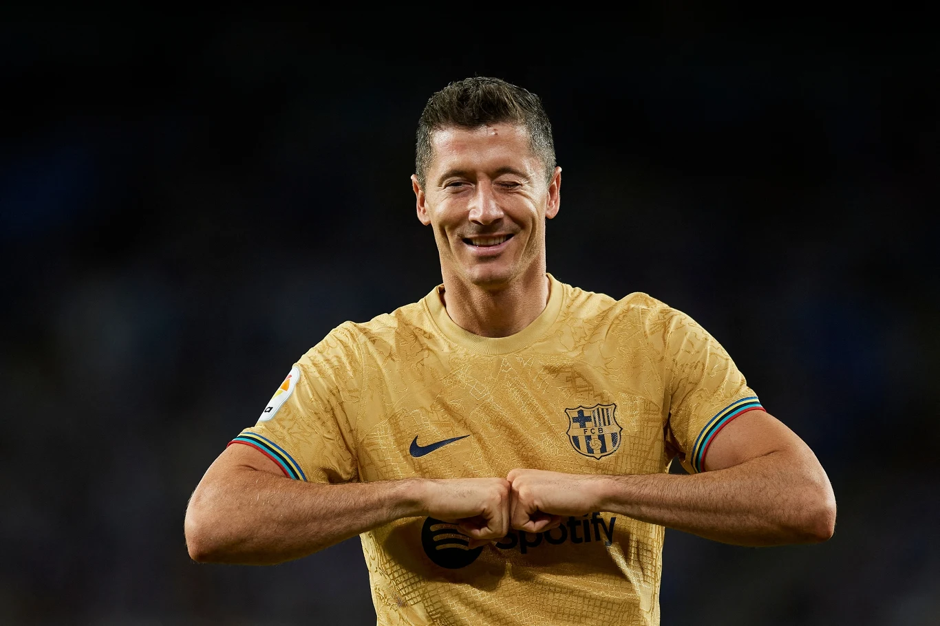 W dniu swoich 34. urodzin Robert Lewandowski strzelił premierowego gola w barwach FC Barcelony Piłkarz uśmiechający się, ubrany w złotą koszulkę klubu FC Barcelona, wykonujący gest dłońmi, z wyraźnie widocznym logo klubu i sponsorów.