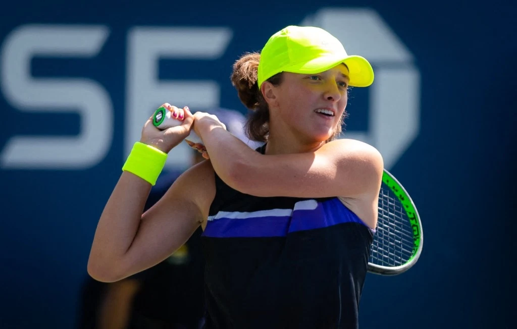 Świątek zadebiutowała w US Open w 2019 roku Tenisistka w jasnej czapce i sportowej odzieży wykonuje zamach do uderzenia rakietą tenisową na korcie.