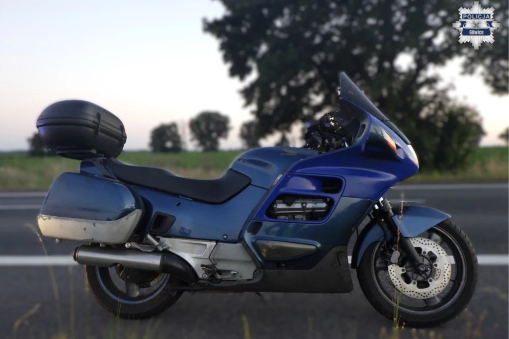 58-latek pomylił drogę. Policjantów zawiadomili inni użytkownicy ruchu drogowego. Granatowy motocykl turystyczny ustawiony na poboczu asfaltowej drogi, w tle rozmyte drzewa i spokojny krajobraz wiejski.