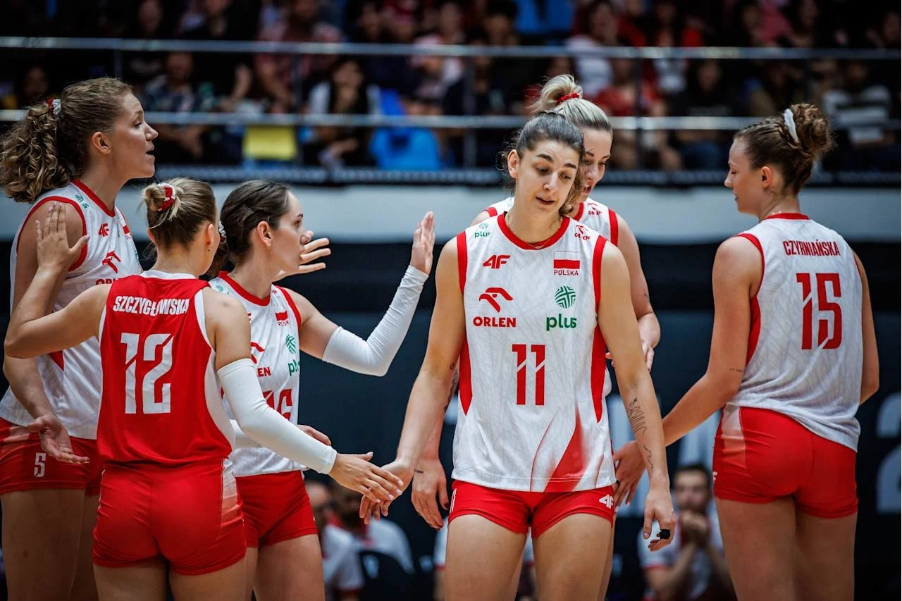 MŚ siatkarek. Polki miały niespodziewane problemy w pierwszym secie, ale ostatecznie wygrały z Wietnamem Zawodniczki drużyny siatkówki w biało-czerwonych strojach rozmawiają ze sobą na boisku podczas meczu, w tle widownia, na twarzach skupienie i sportowe emocje.