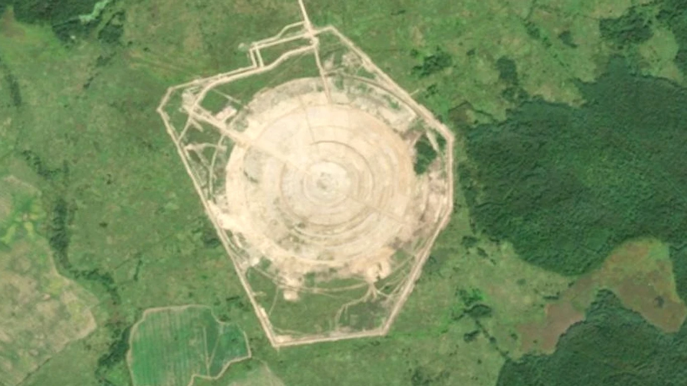 Rosja buduje gigantyczną antenę szpiegowską przy granicy z Polską Okrągła, wykarczowana przestrzeń na tle zielonych terenów leśnych z wyraźnie zaznaczonymi ścieżkami i wieloma koncentrycznymi pierścieniami, otoczona nieregularnym ogrodzeniem.