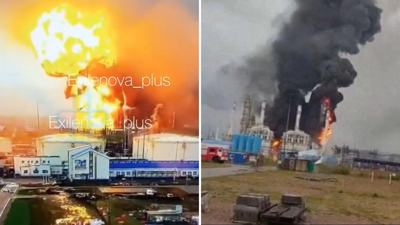 Atak ukraińskich dronów na kluczowy dla Rosji hub Ogromny wybuch ognia i kłęby czarnego dymu unoszące się nad przemysłowym kompleksem z uszkodzonymi i płonącymi zbiornikami, wokół zabudowania fabryczne i wozy strażackie, chaotyczna scena pożaru.