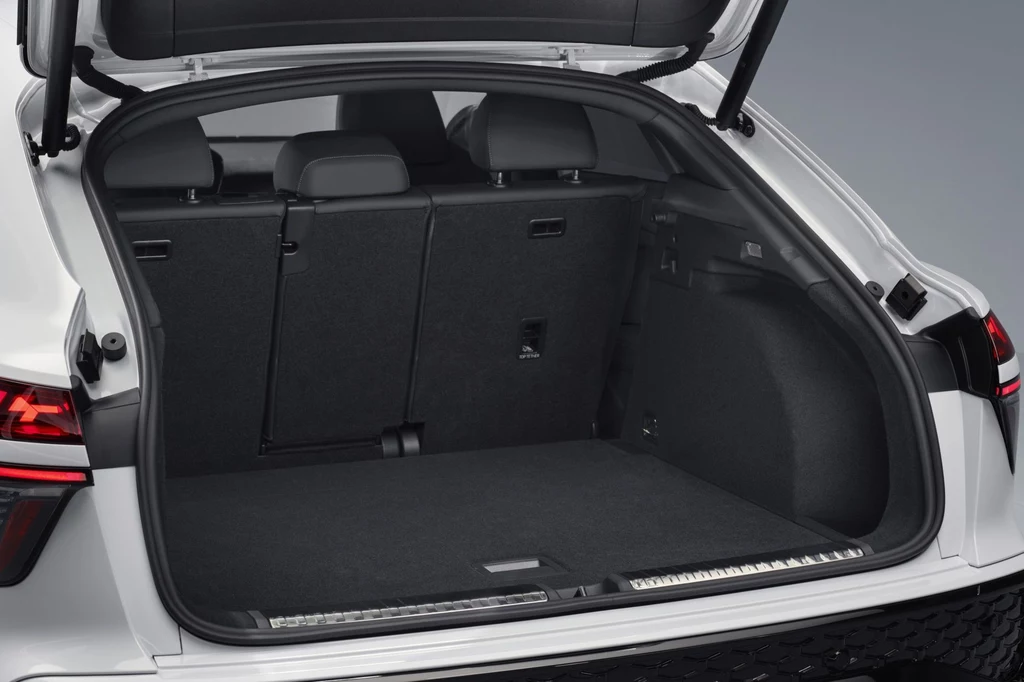 Bagażnik Audi Q3 Sportback ma pojemność do 1 289 litrów. Przestronny bagażnik nowoczesnego samochodu osobowego o czystych, czarnych wykończeniach wnętrza. Tylna kanapa z podzielonymi oparciami umożliwia powiększenie przestrzeni załadunkowej.