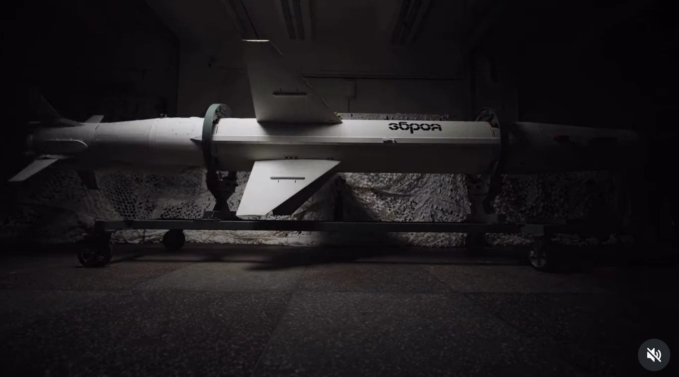 Ukraińskie "ramię zemsty i sprawiedliwości". "Długi Neptun" oficjalnie wchodzi do gry Biała rakieta ustawiona na metalowym stojaku z kółkami, widoczna w ciemnym, przemysłowym pomieszczeniu, z napisem na korpusie i metalowymi obejmami trzymającymi korpus.