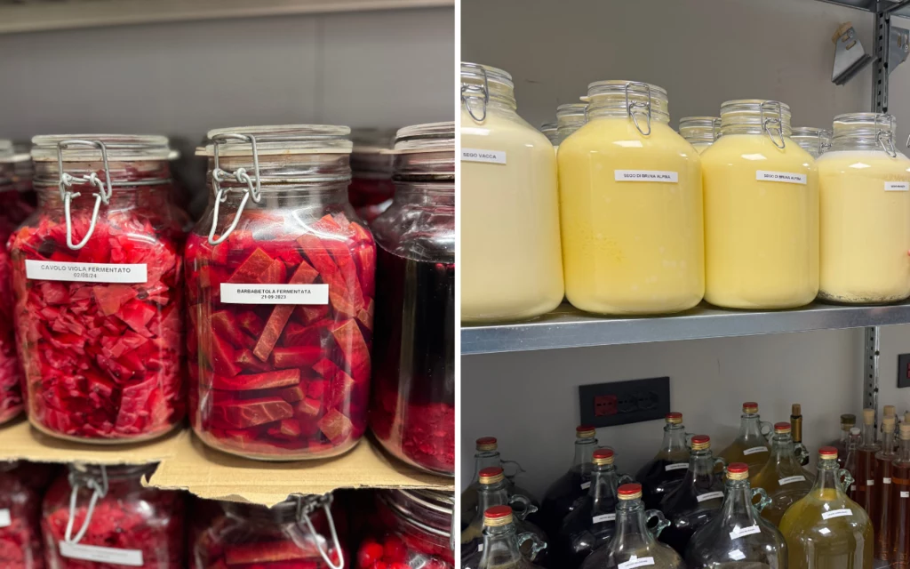 W restauracji prowadzonej przez szefa Talarico zero waste to nie tylko modny slogan Słoiki z przetworzonymi warzywami i kremowymi płynami ustawione na regałach, każda partia podpisana etykietą. Po lewej słoiki z czerwonymi i bordowymi warzywami, po prawej słoiki z żółtym, kremowym płynem. W tle półki z butelkami zamkniętymi korkami.