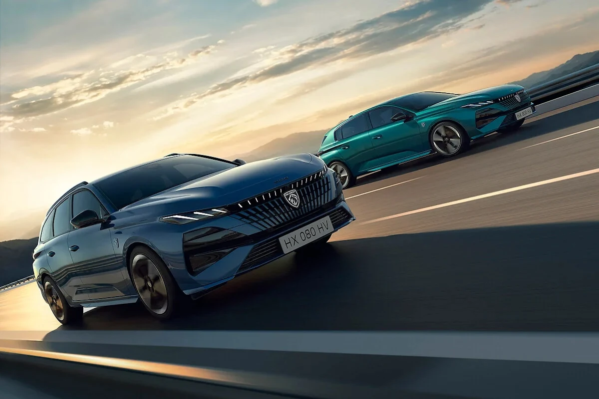 Peugeot 308 po liftingu otrzymał podświetlane logo i grill Dwa nowoczesne samochody osobowe jadące równolegle po szerokiej drodze, przy zachodzie słońca, dynamiczne ujęcie podkreślające nowoczesny design pojazdów