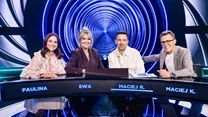 Czworo uśmiechniętych uczestników siedzi przy futurystycznym stole w studio telewizyjnym na tle kolorowych, koncentrycznych okręgów, przed nimi wyświetlają się imiona na ekranach.
