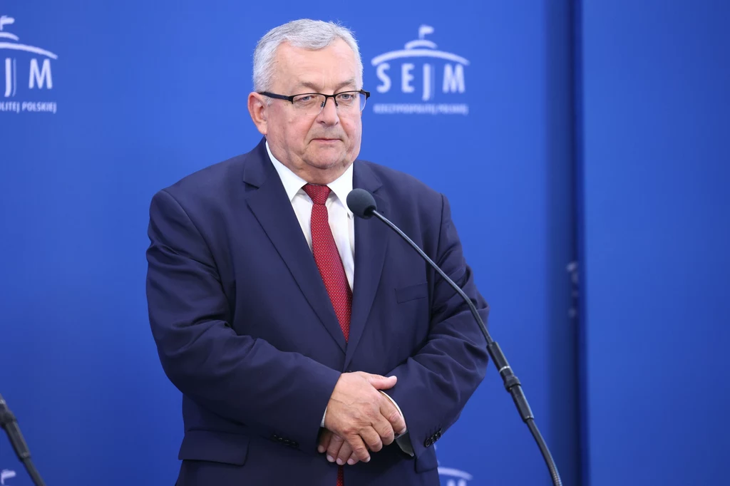 Andrzej Adamczyk zaskarżył przepisy o SCT w Krakowie Mężczyzna w garniturze i czerwonym krawacie stoi przy mikrofonie na tle niebieskiej ściany z napisem SEJM RP