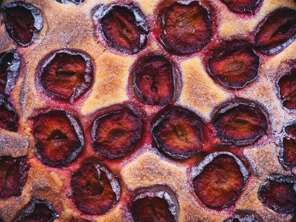 Jabłka, gruszki i inne: takie owoce mogą wylądować w cieście Apetyczne śliwki zatopione w cieście drożdżowym, obsypane delikatnie cukrem, tworzące domowy placek o złocisto-brązowej powierzchni.