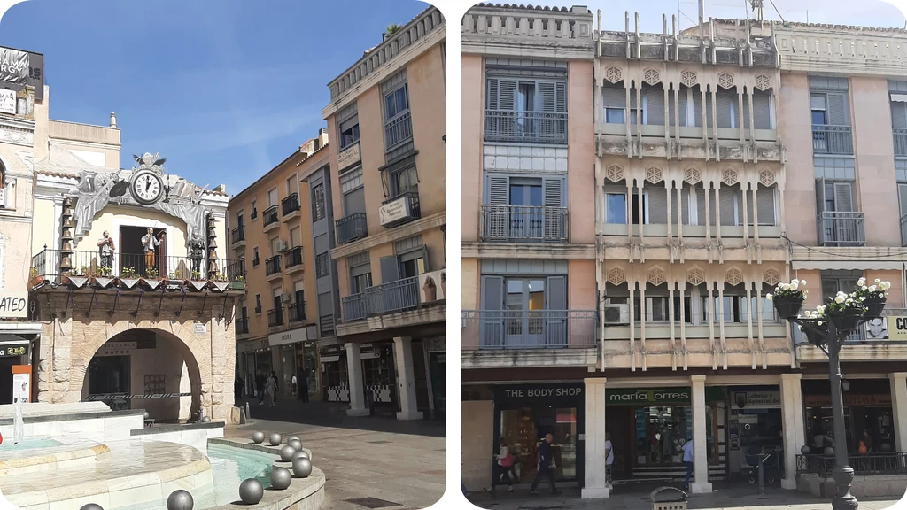 Plac miejski z fontanną, wyjątkowy budynek z zegarem i figurkami mechanicznych postaci oraz fasada kamienicy z licznymi balkonami i dekoracyjnymi detalami architektonicznymi, na parterze sklepy.