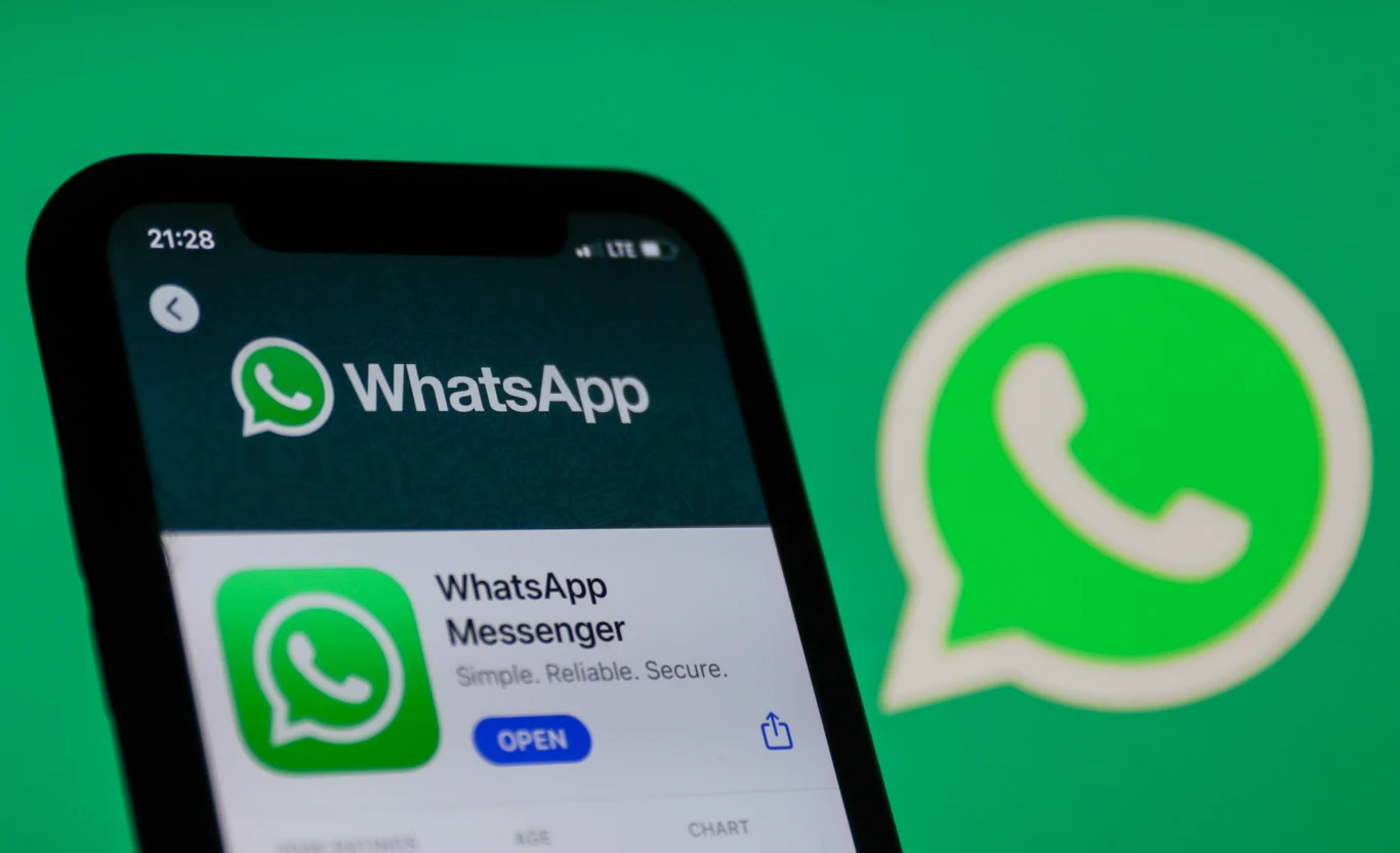 WhatsApp dostał obsługę zdjęć w ruchu Live Photos i Motion Photos. Apka korzysta też na potęgę z Meta AI Ekran telefonu z otwartą stroną WhatsApp Messenger w sklepie App Store na tle powiększonego zielonego logo aplikacji WhatsApp.