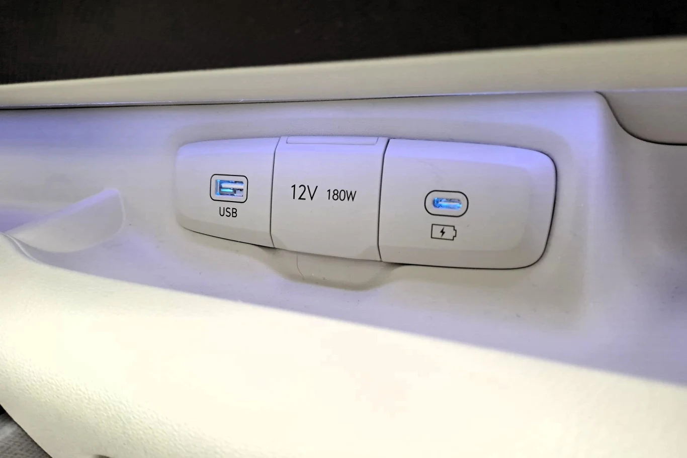 Z gniazda USB typu C telefon można tylko ładować. Jeśli chcemy połączyć go z systemem multimediów, musimy posiadać kabel pasujący do gniazda USB typu A. Panel z gniazdami USB, gniazdkiem 12V 180W i portem do ładowania, umieszczony w jasnym wnętrzu pojazdu.