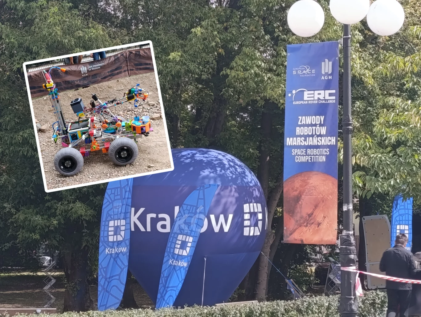 European Rover Challenge w Krakowie na AGH Plenerowa scena z dużym niebieskim balonem promocyjnym i banerami informacyjnymi o zawodach robotów marsjańskich w Krakowie na tle zielonych drzew, w lewym górnym rogu umieszczone jest zdjęcie modelu marsjańskiego łazika zbudowanego z klocków.