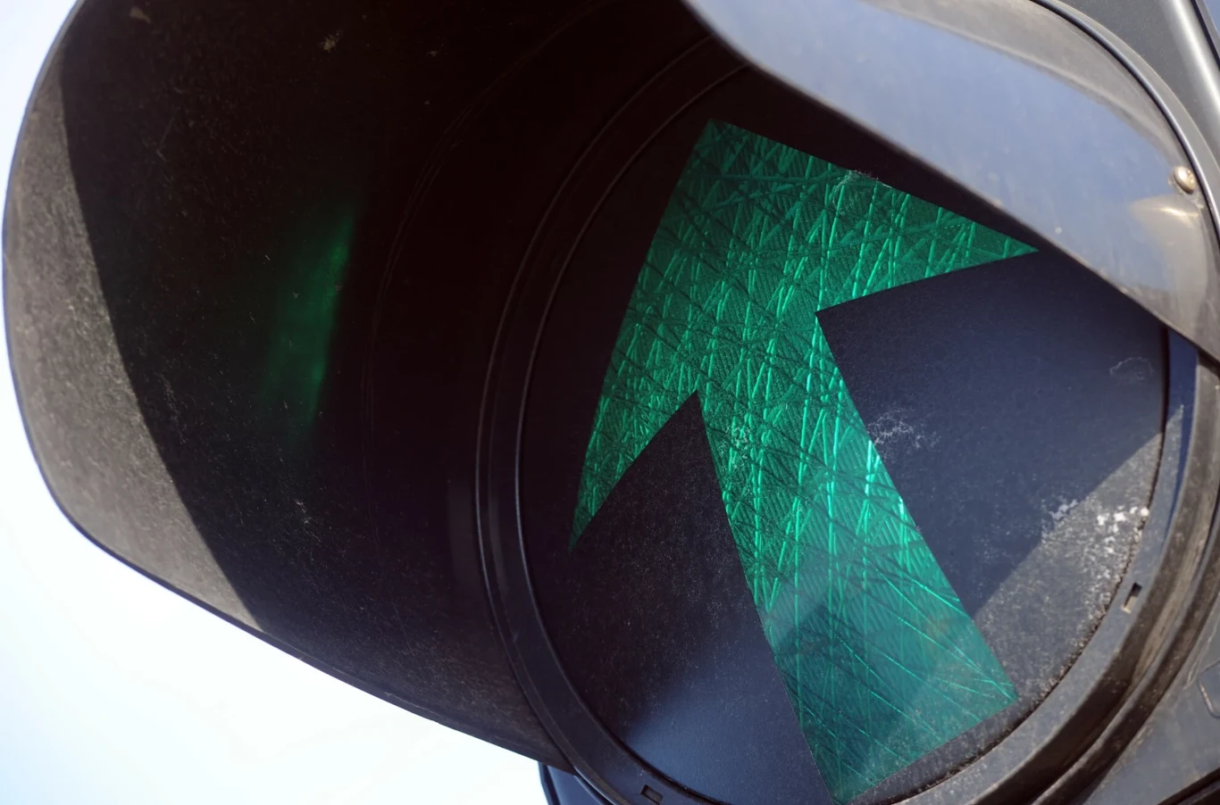 Nie każda zielona strzałka na skrzyżowaniu daje kierowcy prawo do zawracania. Zbliżenie na zielone światło drogowe z wyraźną strzałką skierowaną do góry, wskazującą możliwość ruchu na wprost.