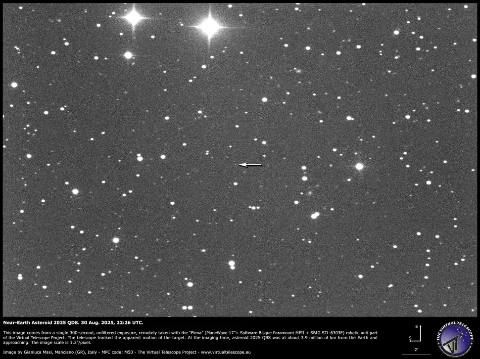 Asteroida 2025 QDB uchwycona przez The Virtual Telescope Project. Czarno-białe zdjęcie nieba gwiaździstego z zaznaczonym strzałką jasnym punktem, którym jest planetoida bliskoziemska oznaczona jako 2023 QD5, otoczona licznymi gwiazdami w tle.