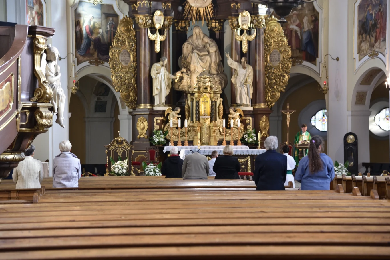 25 maja 2026 Kościół katolicki obchodzi Święto Najświętszej Maryi Panny, Matki Kościoła Wnętrze kościoła z ozdobnym ołtarzem, wierni modlą się, kapłan w zielonych szatach odprawia mszę.
