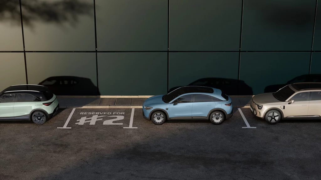 Obecna gama modeli Smarta obejmuje wyłącznie duże pojazdy. #2 ma to zmienić Trzy nowoczesne samochody elektryczne zaparkowane przed szklaną ścianą budynku, jeden z nich stoi na miejscu oznaczonym jako zarezerwowane numer dwa.