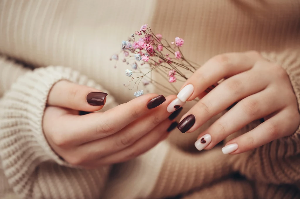 Brązowy manicure pięknie współgra z mlecznym odcieniem i delikatnymi zdobieniami