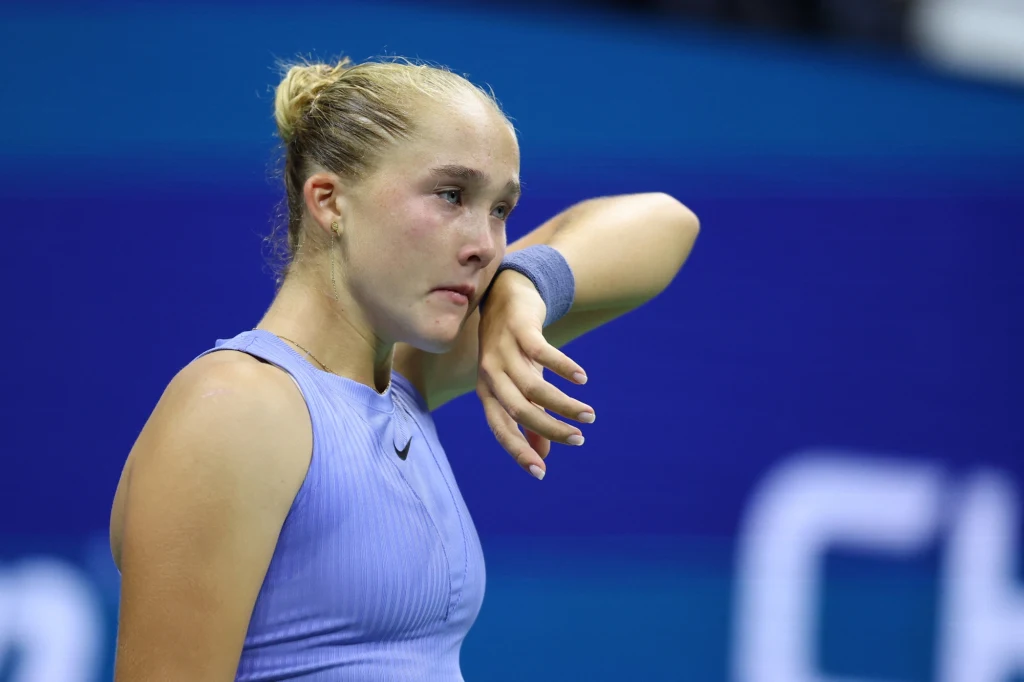 Mirra Andriejewa zakończyła swoją przygodę w US Open 2025 Młoda kobieta w sportowym stroju na tle niebieskiego boiska do tenisa ocierająca łzę z policzka, z wyraźnym wyrazem emocji na twarzy po wysiłku fizycznym.