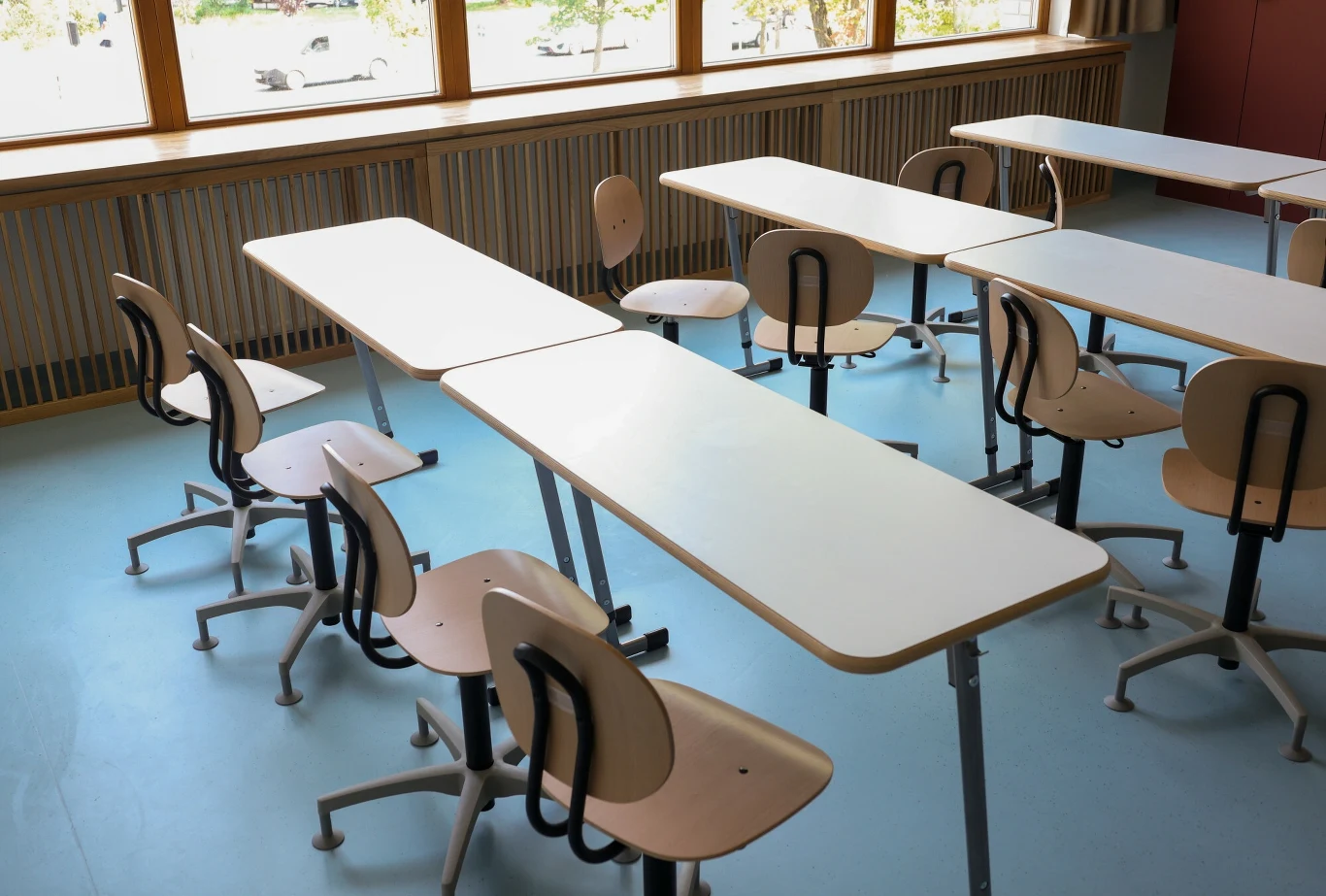 Wicedyrektor szkoły w Starachowicach zareagowała po głośnym występie uczniów (Zdj. ilustracyjne) Puste, nowoczesne ławki i krzesła w jasnej sali lekcyjnej ze światłem dziennym wpadającym przez duże okna, przestrzeń uporządkowana i zadbana.