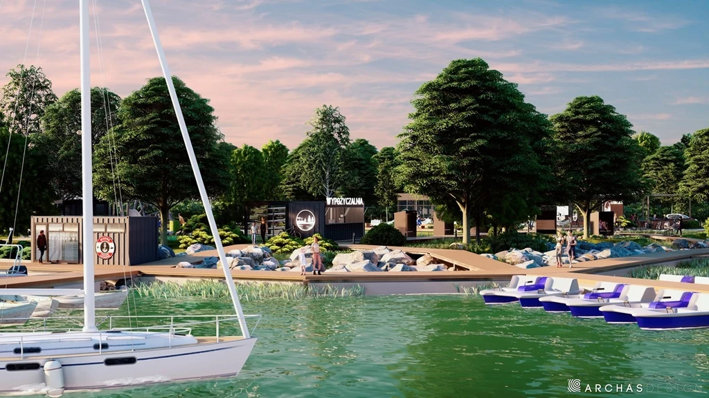 Wizualizacja przystani dla łodzi, która powstanie w ramach kompleksu Laguna Beskidów nad Jeziorem Żywieckim (wizualizacja) Nowoczesna marina z pomostami, łódką żaglową na wodzie, rekreacyjnymi rowerami wodnymi i otoczeniem pełnym zielonych drzew, w tle zabudowania funkcjonalne i przestrzeń wypoczynkowa.