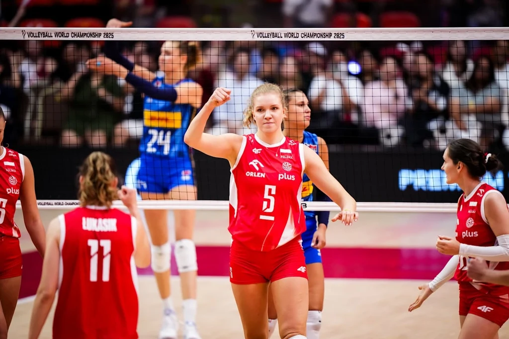Zawodniczka reprezentacji Polski w siatkówce świętuje zdobycie punktu na tle koleżanek z drużyny i rywalek w żółto-niebieskich strojach podczas meczu siatkarskiego mistrzostw świata.