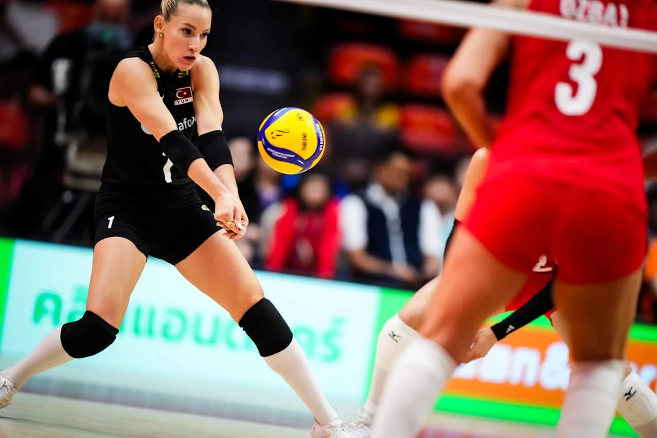 MŚ siatkarek. Mecz Turcja - USA rozpoczął się dla mistrzyń Europy idealnie Siatkarka w czarnej koszulce wykonuje odbiór piłki podczas meczu, naprzeciwko niej zawodniczka w czerwonym stroju, w tle widać publiczność i hale sportową.