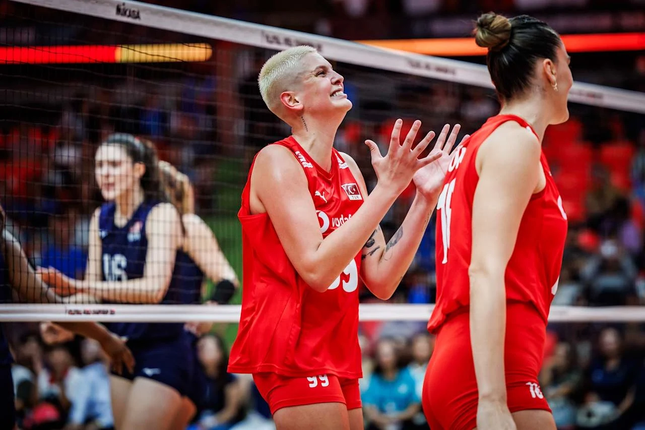 MŚ siatkarek. Turcja z Ebrar Karakurt w składzie uzupełniła listę półfinalistek Siatkarki w czerwonych strojach okazujące emocje po rozegranej akcji podczas meczu siatkówki, widoczna siatka oraz zawodniczki drużyny przeciwnej w tle.