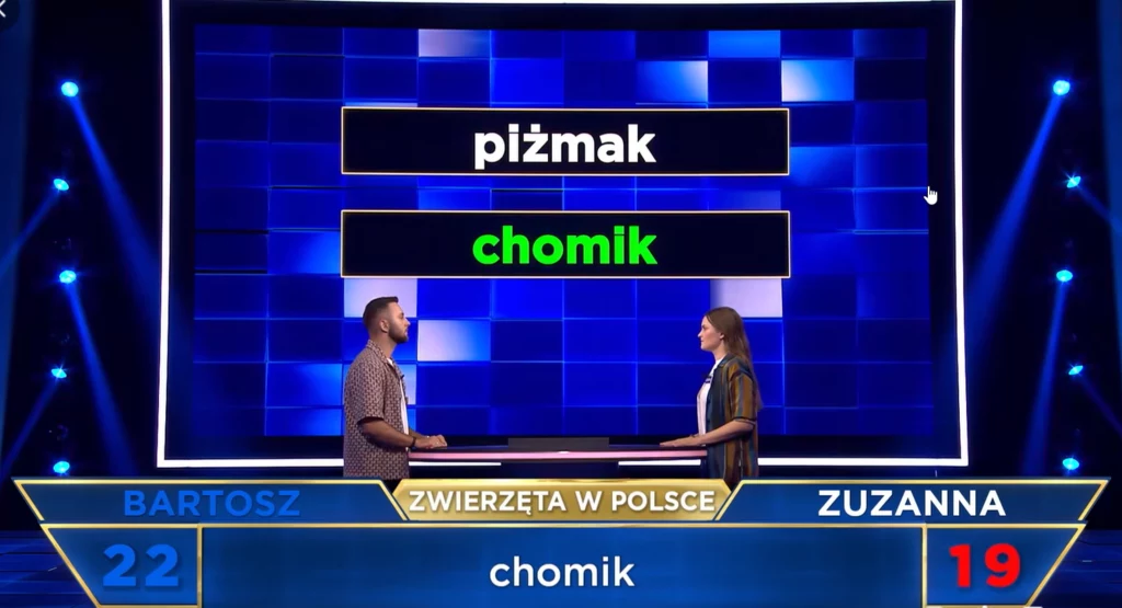Teleturniej "The Floor" z pytaniem o chomika i piżmaka Fragment znanego teleturnieju, dwóch uczestników stoi naprzeciwko siebie przy pulpitach, nad nimi na dużym ekranie wyświetlone są słowa 'piżmak' i 'chomik', na dole widać wyniki oraz imiona zawodników Bartosz i Zuzanna.