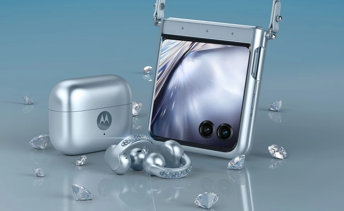 Nowoczesny składany smartfon Motorola w srebrnym kolorze, etui na słuchawki bezprzewodowe oraz wyeksponowane srebrne słuchawki, otoczone dekoracyjnymi kryształkami.