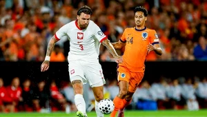 Przemysław Wiśniewski of Poland passes the ball under pressure from Tijjani Reijnders of the Netherlands during the UEFA World Cup Qualifiers match between Netherlands and Poland at Stadion Feijenoord on September 4, 2025 in Rotterdam, Netherlands. (Photo
