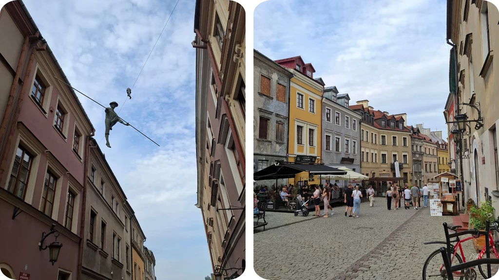 Figura akrobaty balansująca na linie rozciągniętej między budynkami na tle nieba, po prawej stronie zabytkowa, kolorowa starówka z brukowaną uliczką, kawiarnianymi ogródkami i przechodniami.
