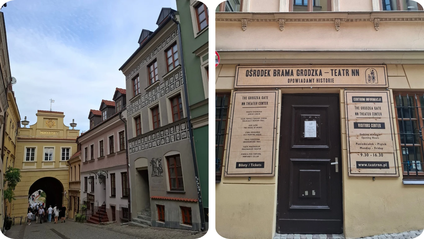Kolorowe kamienice wzdłuż brukowanej ulicy prowadzącej do zabytkowej bramy oraz fasada budynku z wejściem do Ośrodka Brama Grodzka – Teatr NN, na którym widnieją tablice informacyjne i harmonogram wydarzeń.