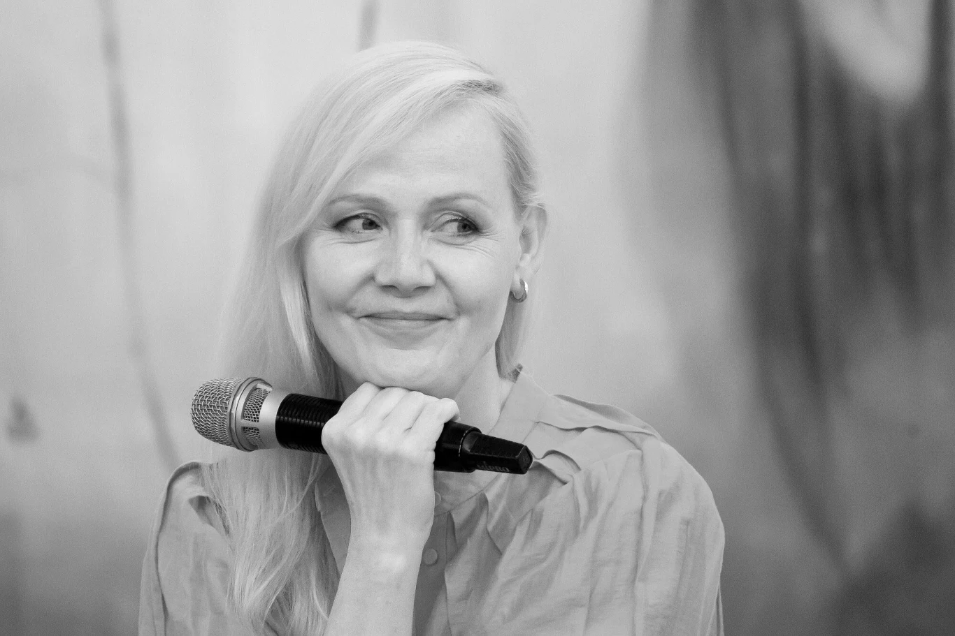 Katarzyna Stoparczyk zginęła w wypadku samochodowym Kobieta o jasnych włosach trzyma mikrofon w dłoni, z delikatnym uśmiechem na twarzy, ubrana w koszulę, patrząca lekko w bok.
