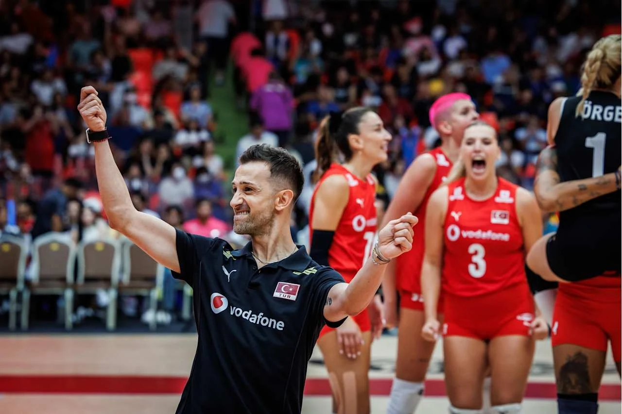 Daniele Santarelli doprowadził Turcję do finału mistrzostw świata Trener drużyny siatkarskiej z podniesionymi rękami w geście triumfu, w tle zawodniczki w czerwonych strojach okazujące emocje po zdobytym punkcie.