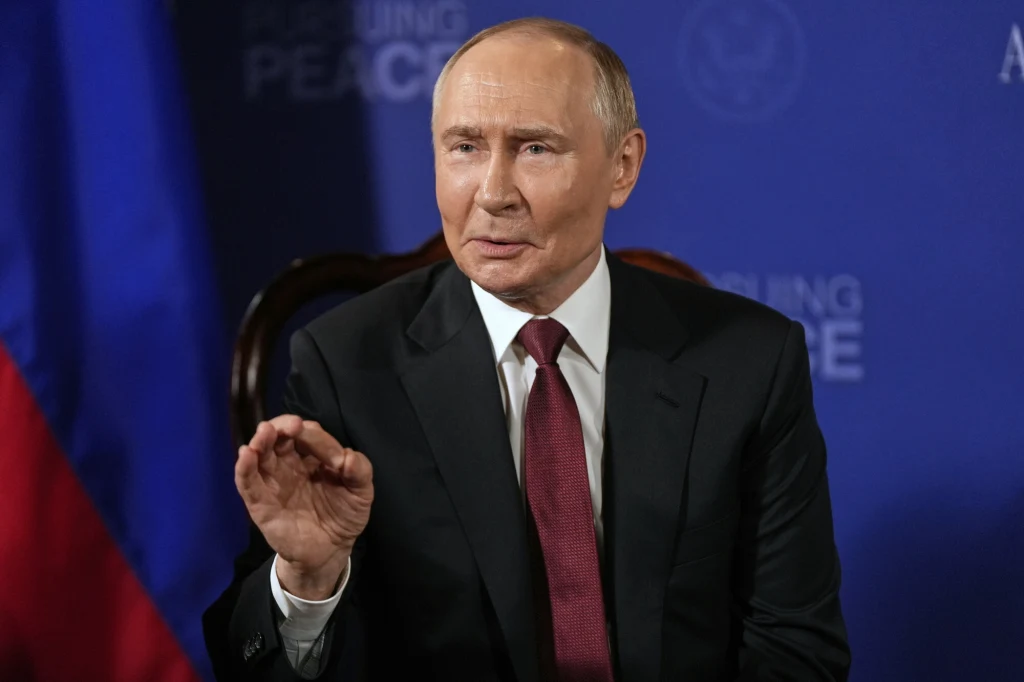 Zachodnie media: Przesmyk suwalski może być celem rosyjskiego ataku Mężczyzna w ciemnym garniturze i bordowym krawacie siedzi na krześle na tle niebieskiego baneru, wykonuje gest dłonią jakby akcentował wypowiedź.