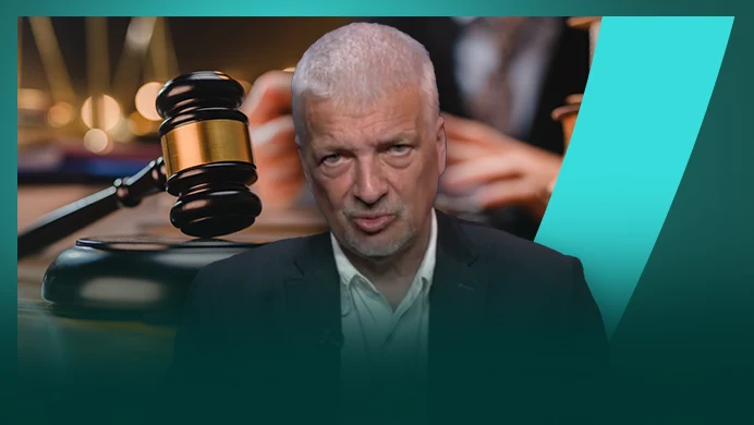 Gwiazdowski mówi Interii Starszy mężczyzna o siwych włosach w garniturze na pierwszym planie, tło z dużym młotkiem sędziowskim i rozmytym wizerunkiem osoby w togach sędziowskich, motyw nawiązujący do tematyki sądownictwa lub prawa.