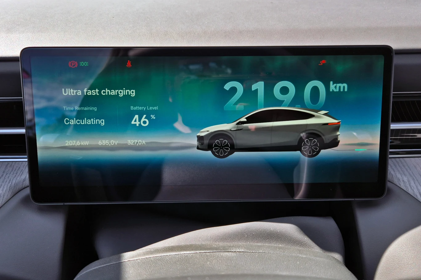 Xpenga G6 można naładować do 80 proc. w zaledwie 12 minut, zakładając że znajdzie się odpowiednio mocną ładowarkę. Ja podczas jazd w Niemczech natrafiałem tylko na takie o mocy "zaledwie" 200 kW Interfejs wyświetlacza w samochodzie elektrycznym pokazujący dane dotyczące ultraszybkiego ładowania, poziomu naładowania baterii na 46% oraz szacowanego zasięgu 2190 kilometrów, z grafiką auta na tle niebieskiego gradientu.